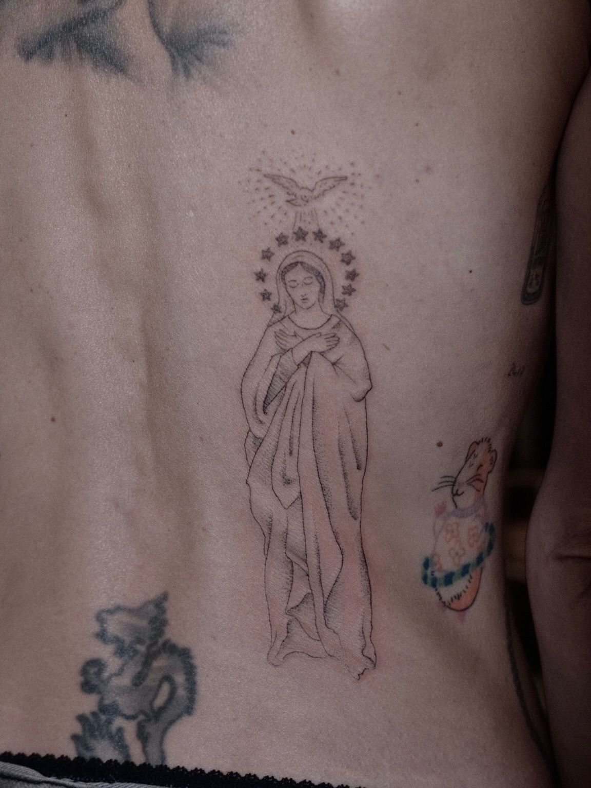 Large fine line Madonna with a halo of stars along the spine